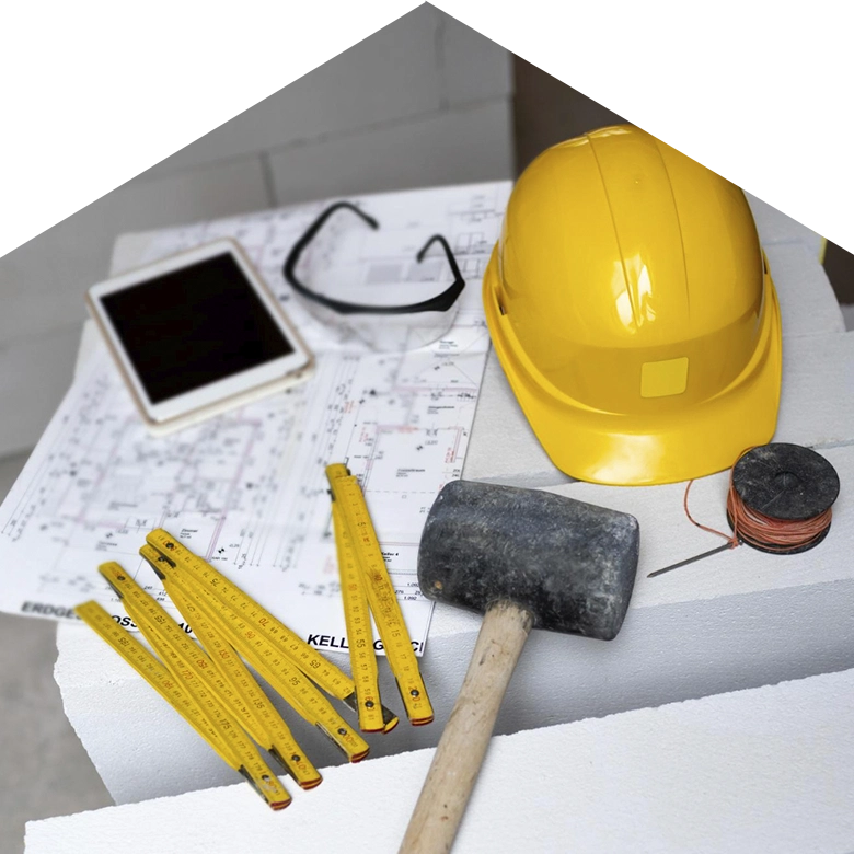 foto con forma de casa con plano, casco y herramientas construcción